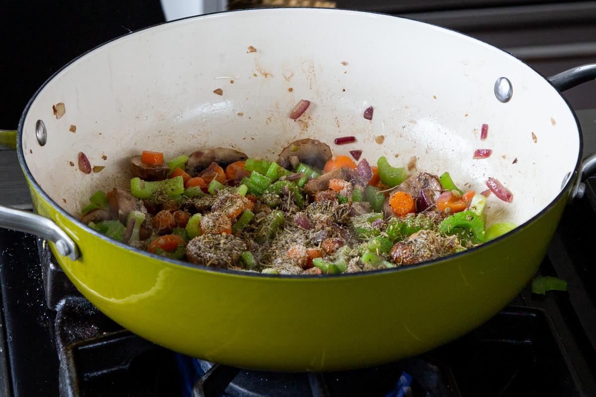 adding sauces and spices to the mushrooms, celery, and carrots, after cooking