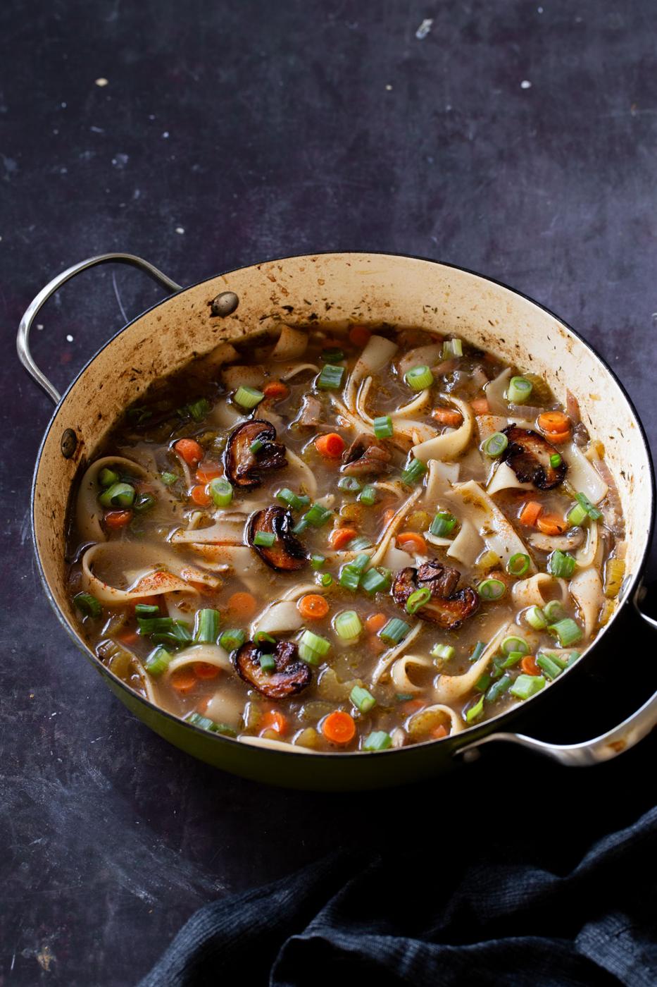 angled shot of mushroom noodle soup in the pan