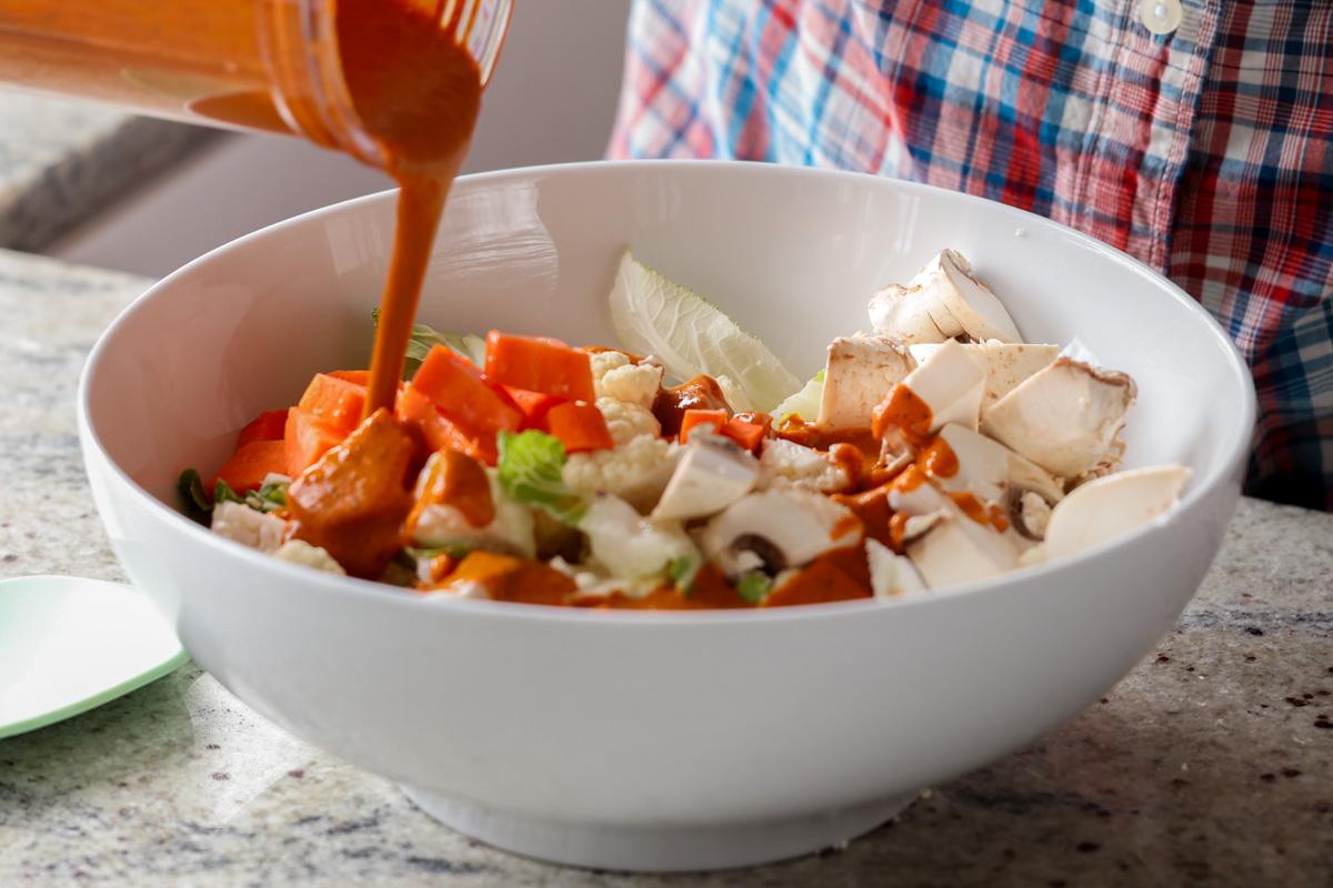 adding the spice paste to the bowl