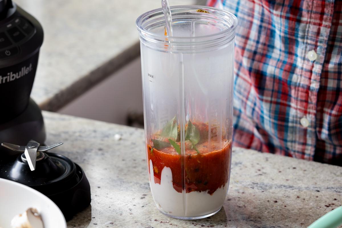 adding spice paste ingredients to the blender
