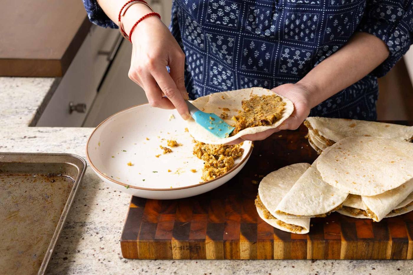 filling a tortilla with paratha filling