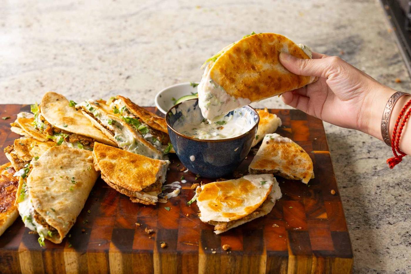 dipping a paratha taco into raita