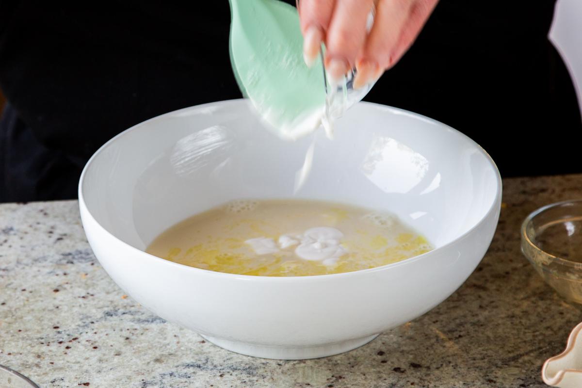 adding non-dairy yogurt to the wet ingredients in a mixing bowl