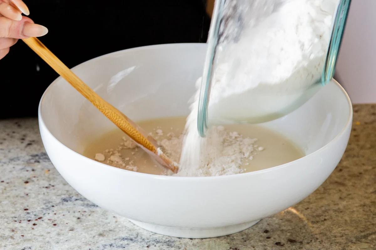 adding dry ingredients to the wet in the mixing bowl