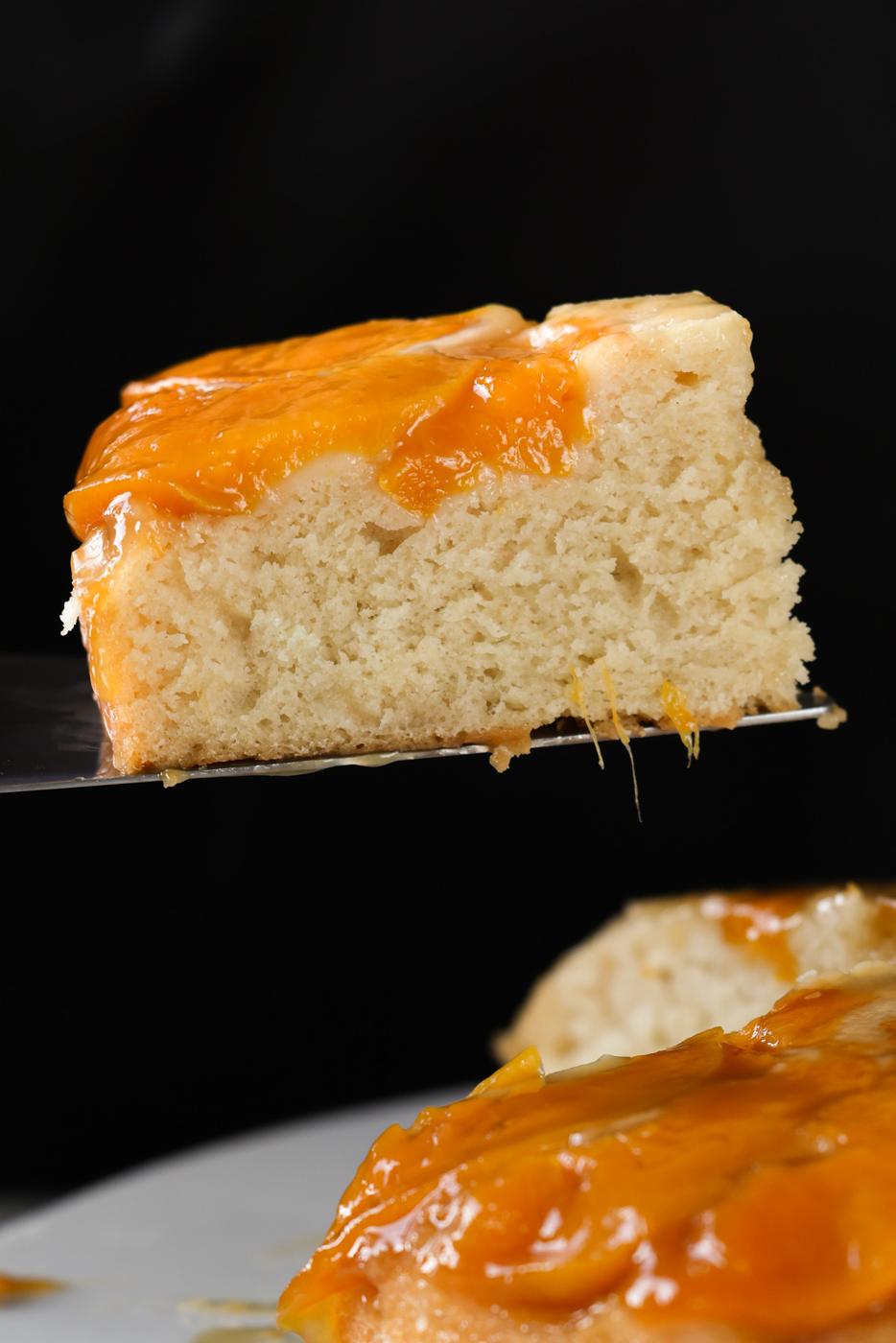serving a slice of peach upside-down cake