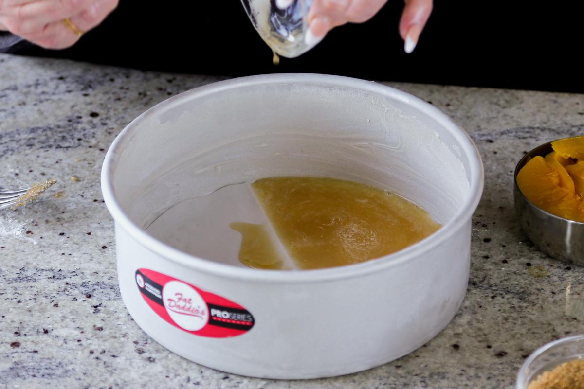 pouring the butter-maple syrup mixture into the lined cake pan