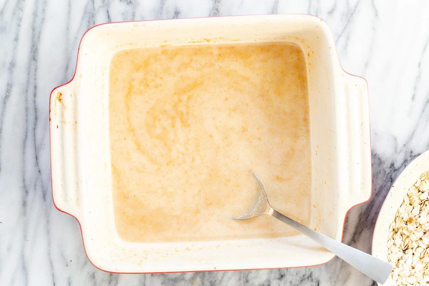 Ingredients for Peanut Butter and Jelly Oatmeal in a white baking dish
