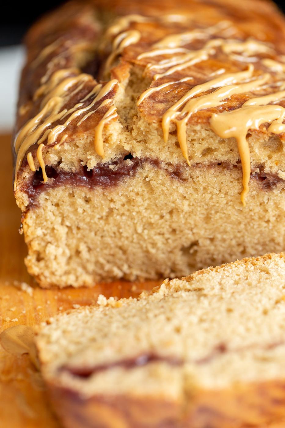 close up of a sliced loaf of vegan peanut butter and jelly cake with jam swirl