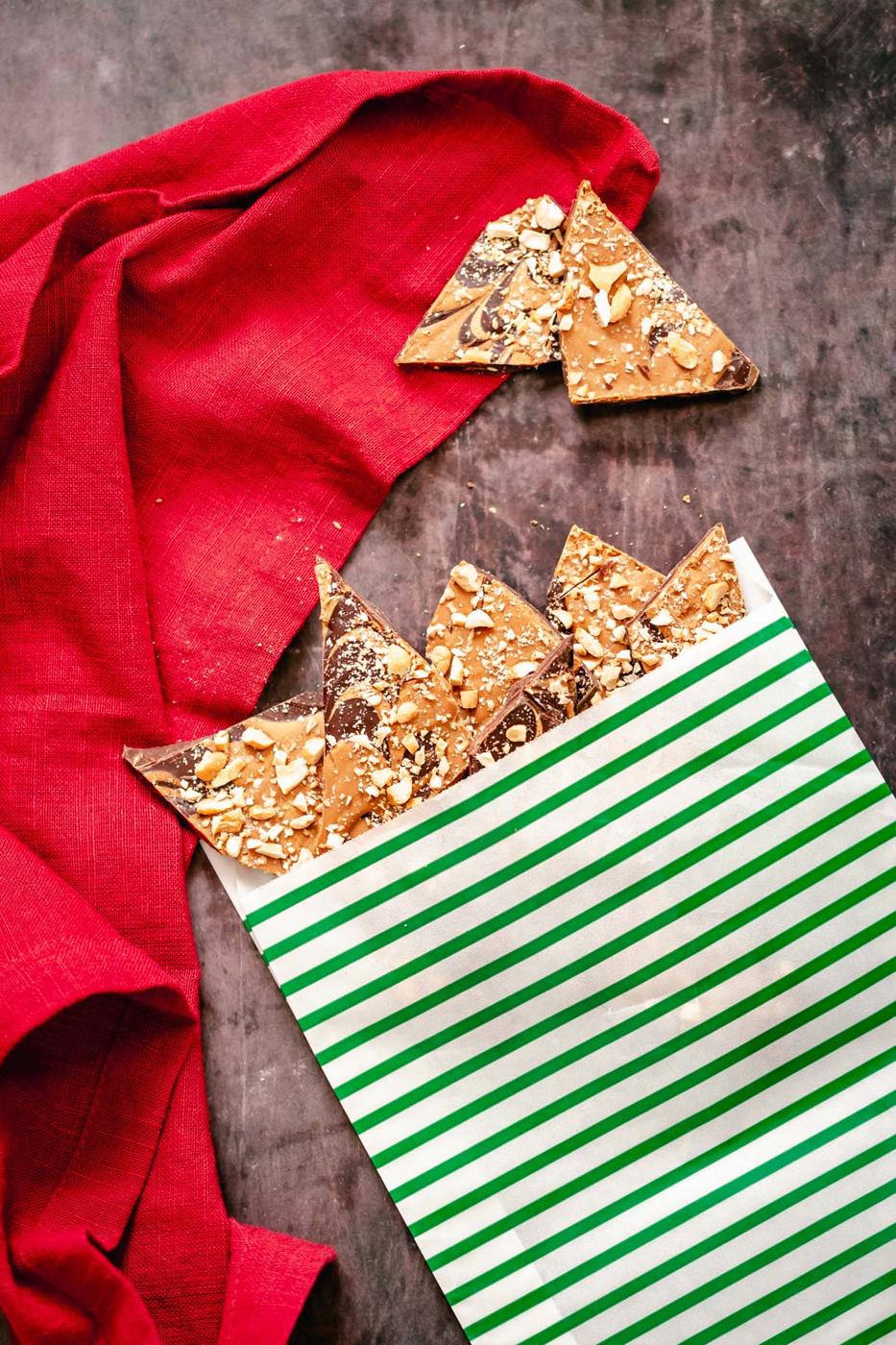 homemade vegan peanut butter cup chocolate bark in a green and white Christmas paper bag