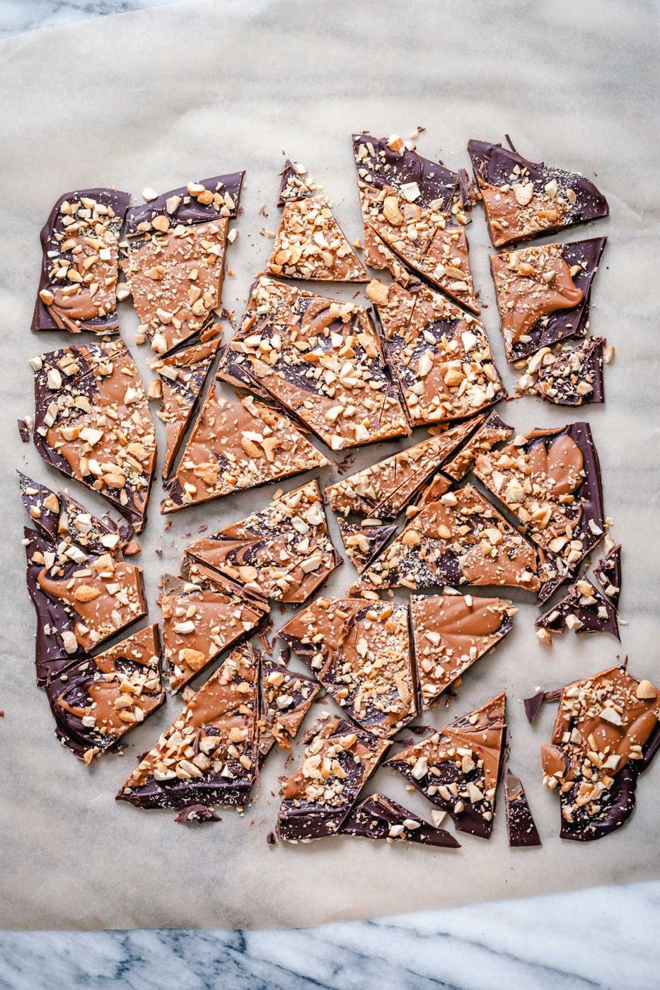 overhead shot of broken up peanut butter cup chocolate bark on a sheet of parchment paper