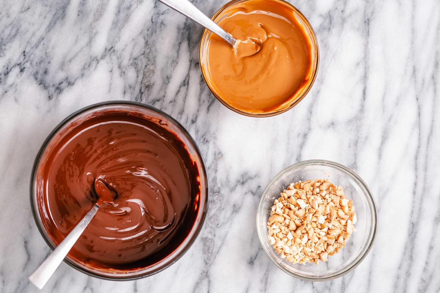 melted chocolate, melted peanut butter and crushed peanuts ready for making peanut butter chocolate bark