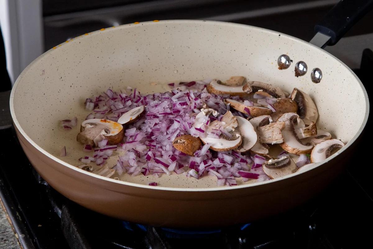 adding onion and mushrooms to the pan