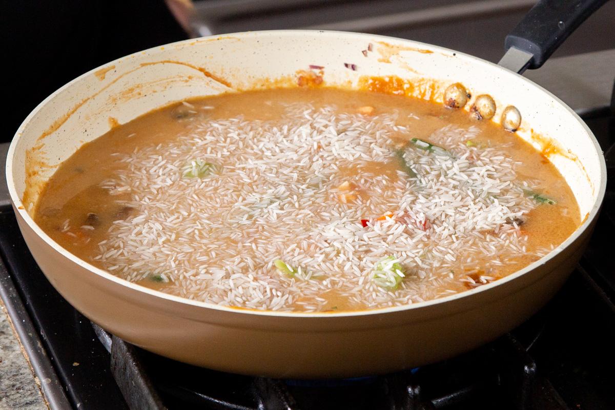 adding rice to the pan