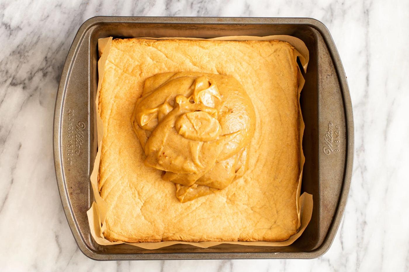 vegan date caramel being spread on top of cookie crust