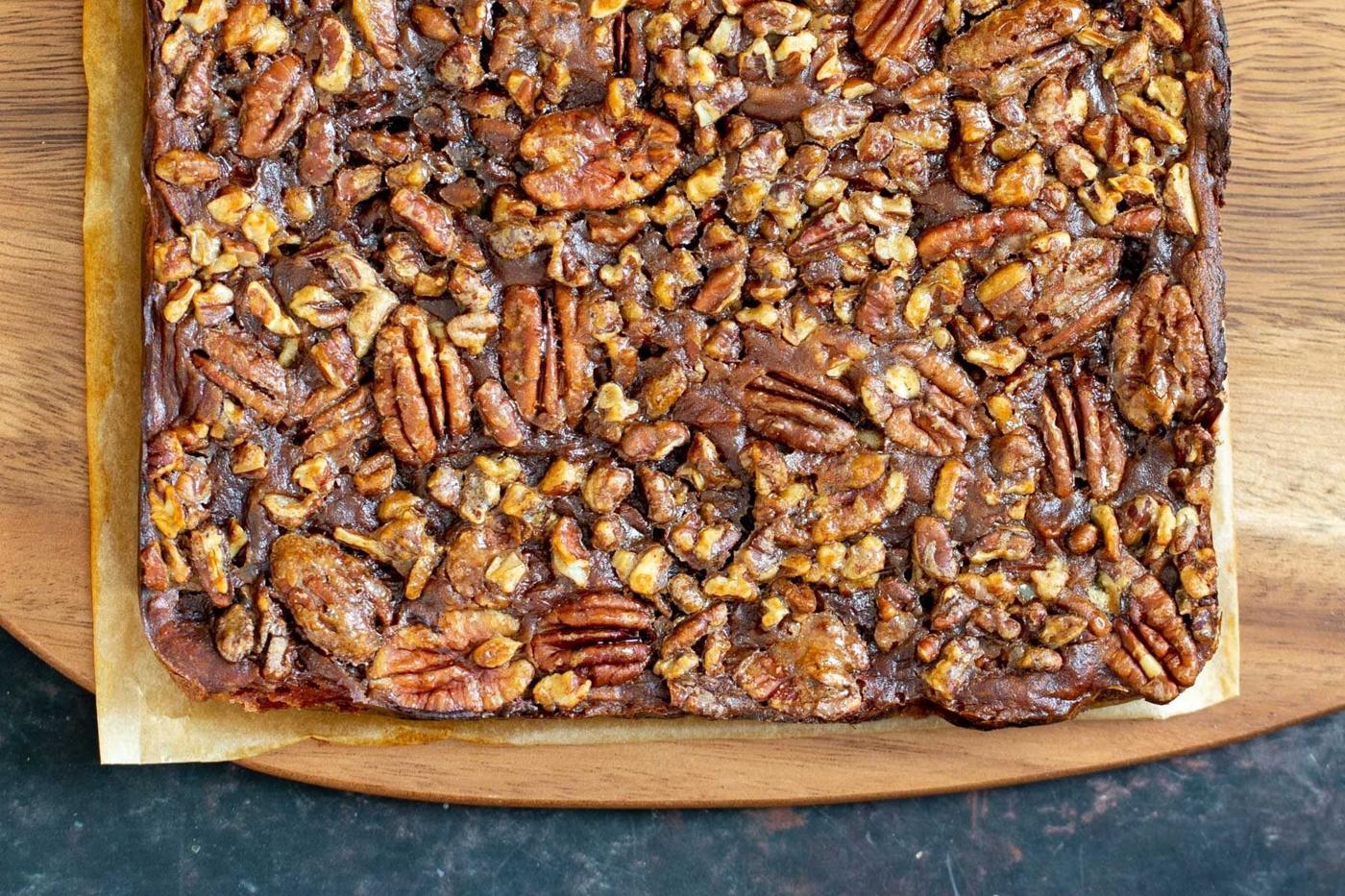 vegan pecan pie bars on a wooden chopping board