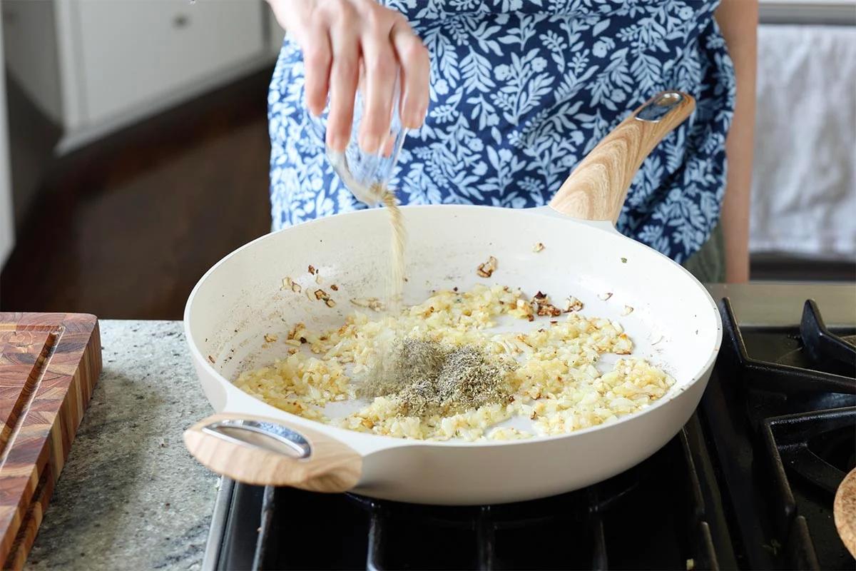 adding pepper to the pan