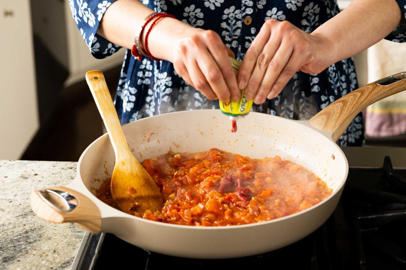 adding tomato paste to the pan