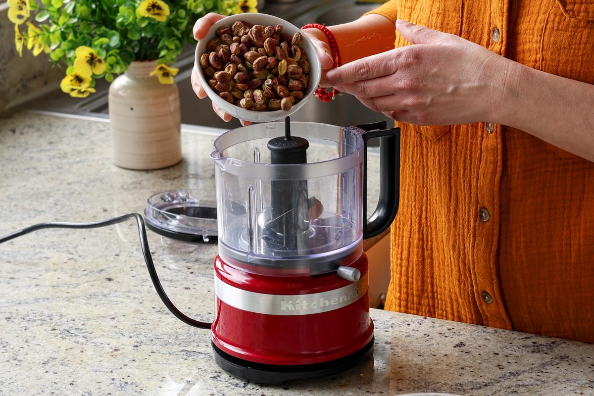 adding pistachios to the food processor
