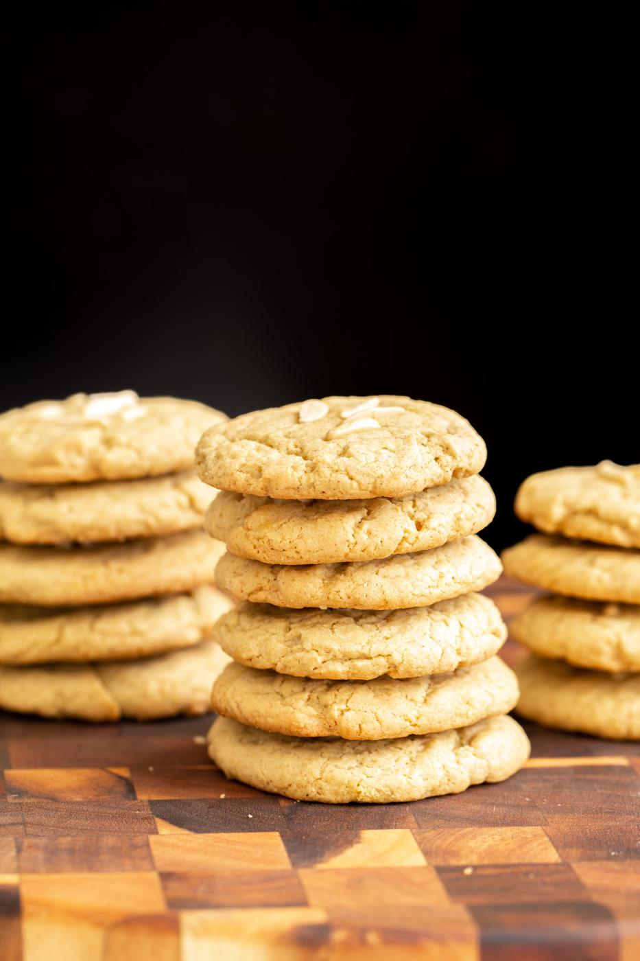 stacked vegan pistachio cookies on a wooden board