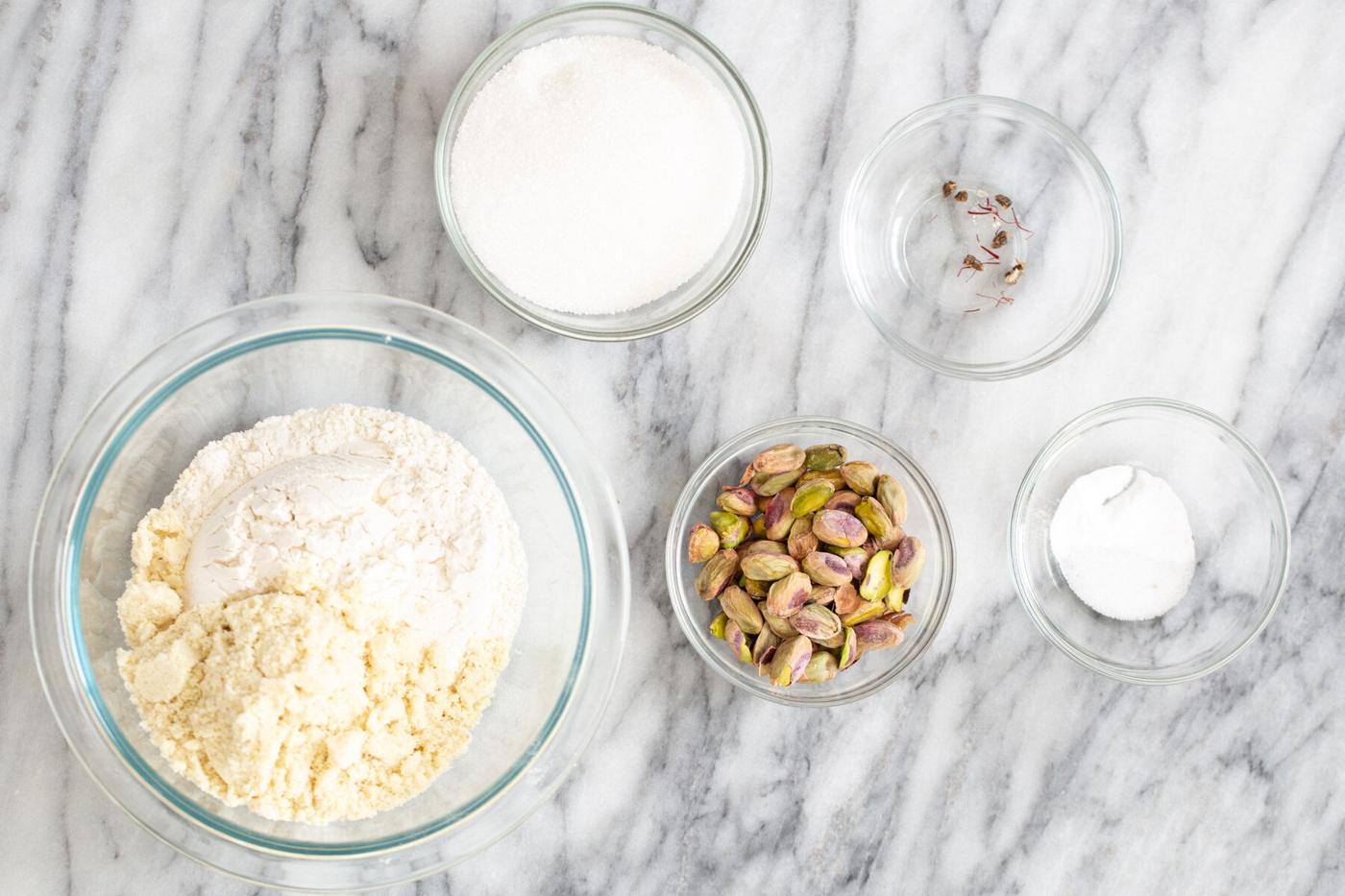 ingredients for vegan pistachio cookie recipe on a marble kitchen counter
