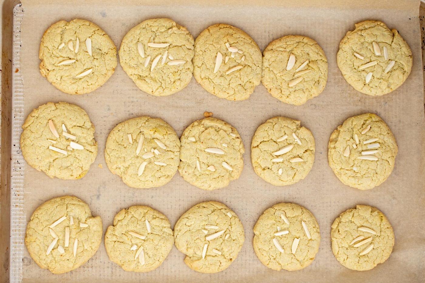 freshly baked vegan pistachio cookies on a lined sheet pan