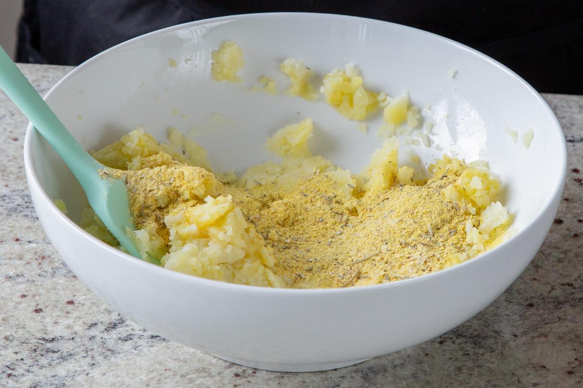 adding nutritional yeast and spices to the cauliflower mash