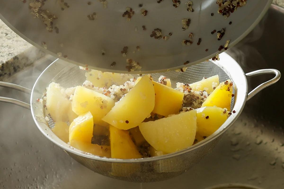 adding potatoes and quinoa to the bowl