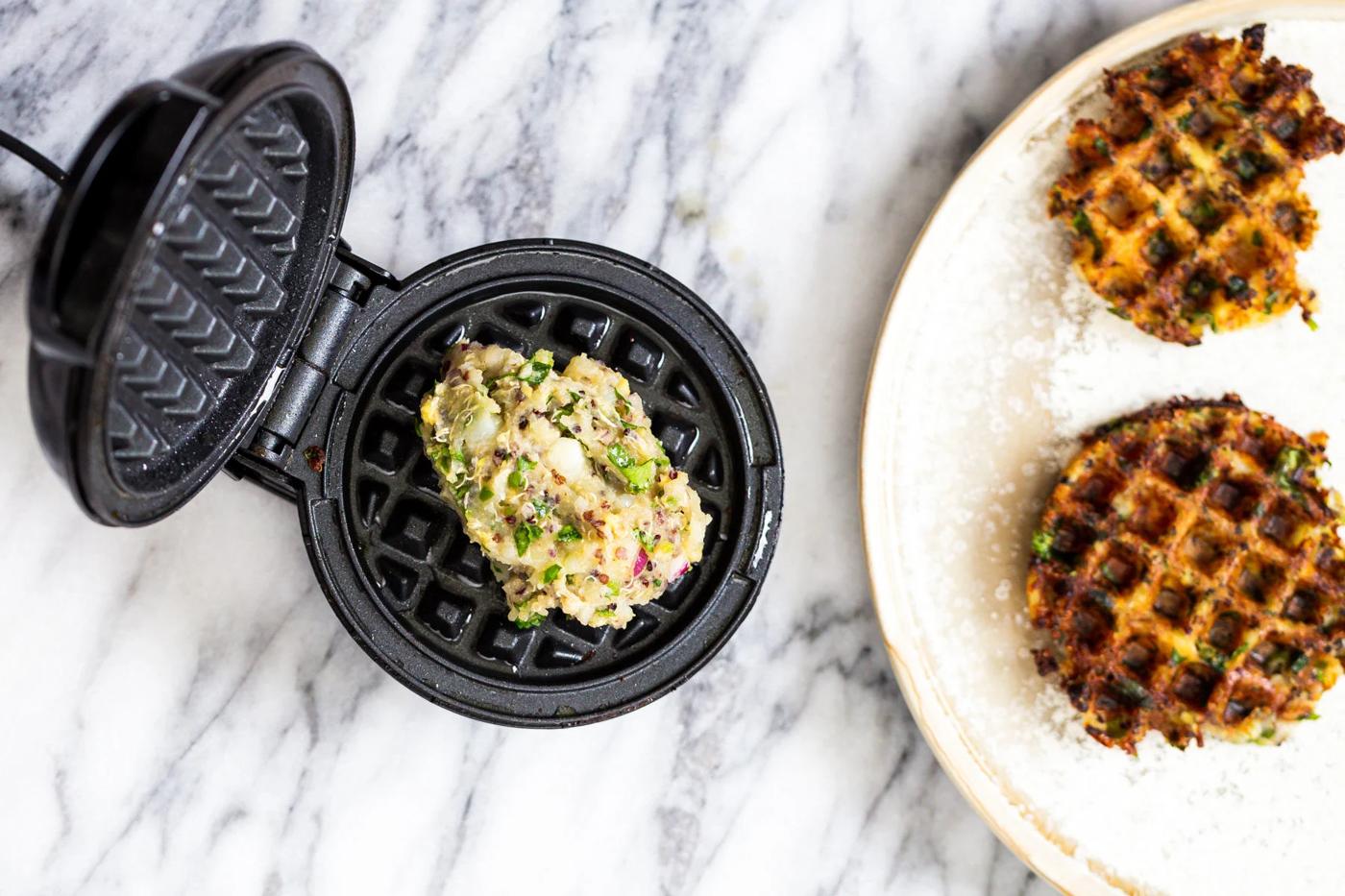 Indian spiced crispy vegan potato quinoa waffles being baked in a waffles iron