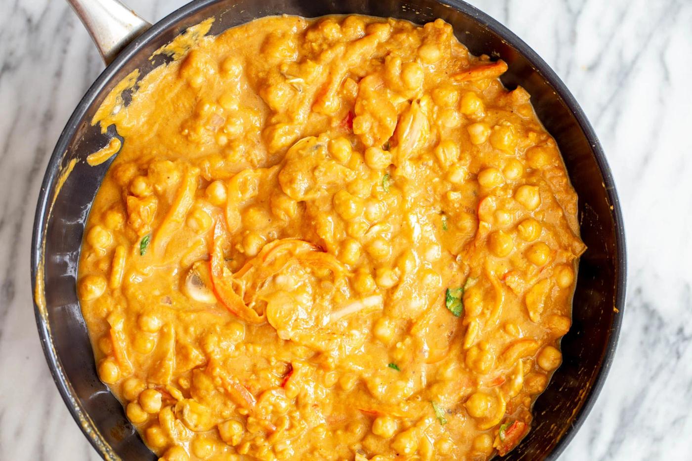 chickpeas being cooked in pumpkin gravy for making curry