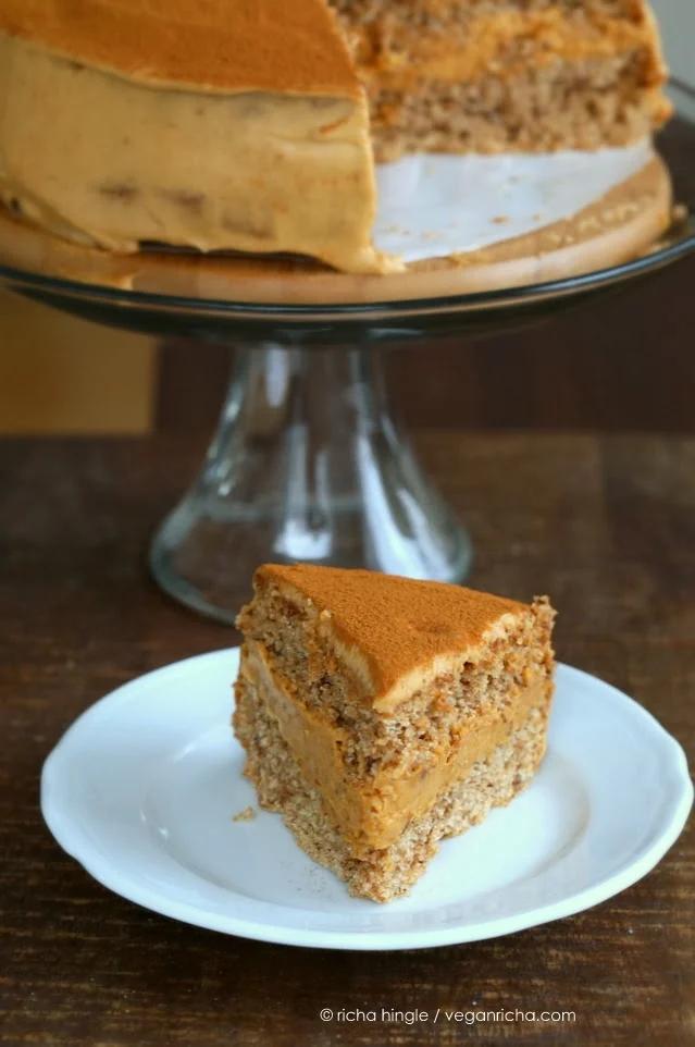 a slice of vegan pumpkin mousse cake with spelt flour vanilla sponge on a white dessert plate