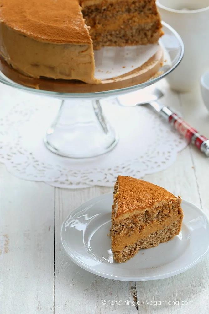 a slice of healthy vegan pumpkin mousse cake next to a glass cake stand