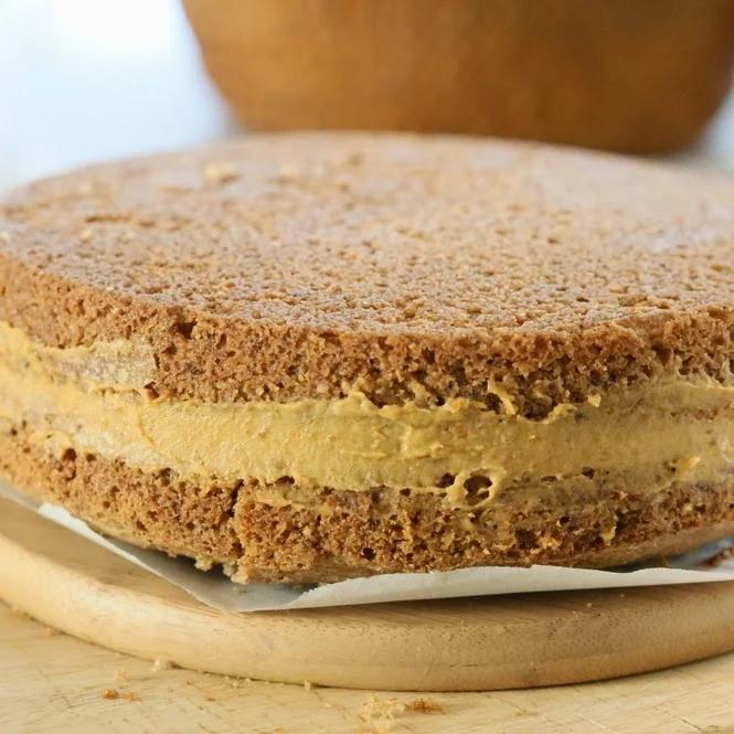 vanilla sponge cake being layered with pumpkin mousse to make mousse cake