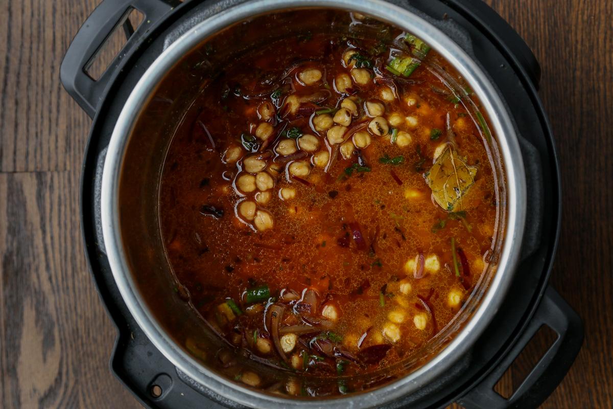 adding dried spices and water to the chickpea mixture