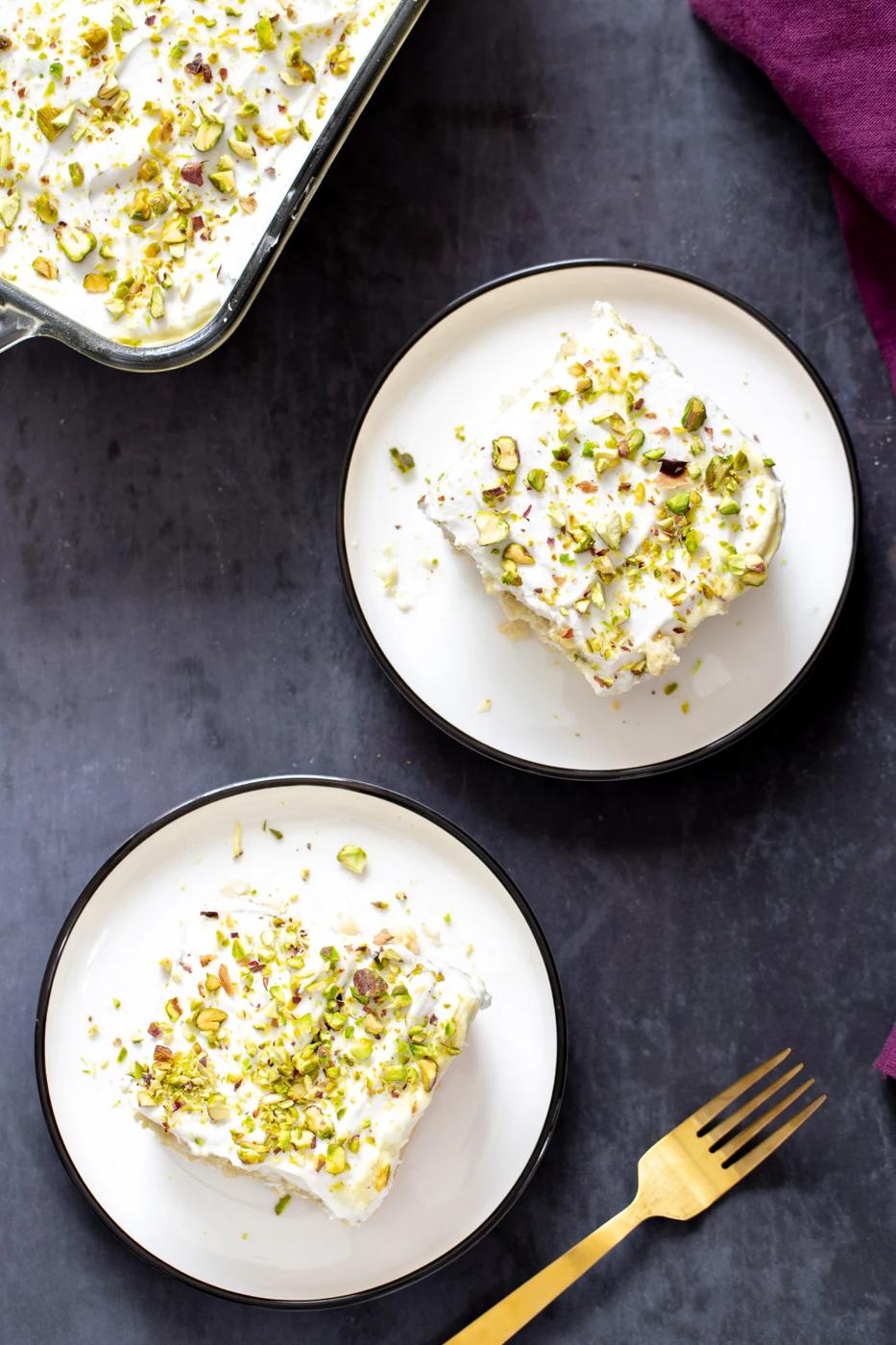 overhead shot of two slices of vegan tres leches sprinkled with pistachios