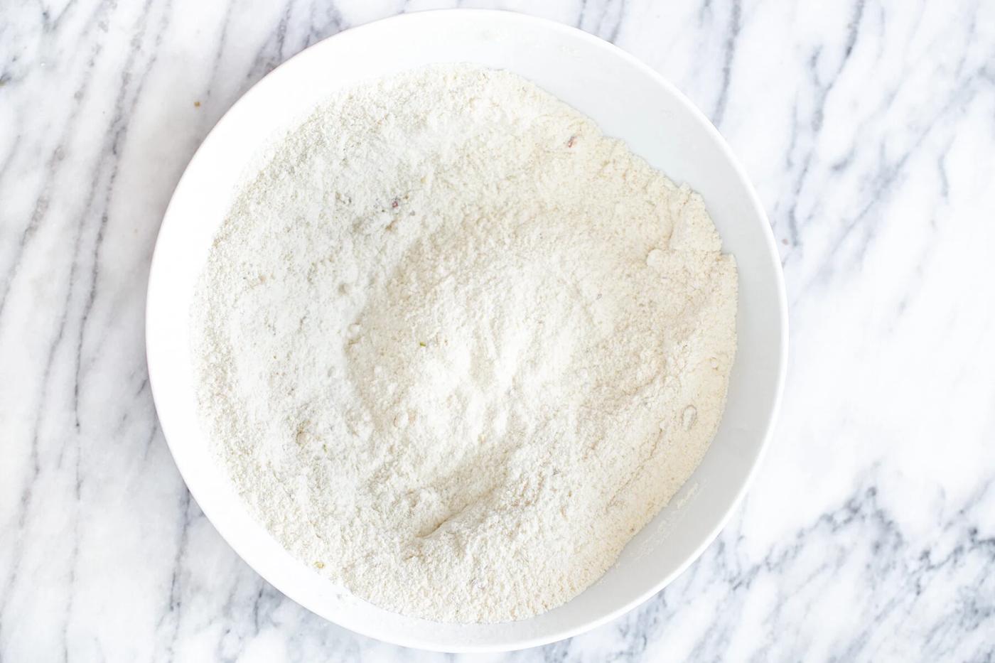 dry ingredients for vegan tres leches cake in a white bowl