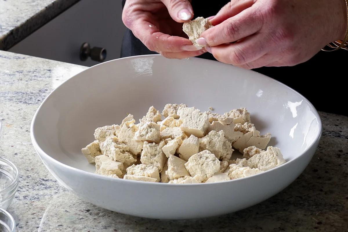 tearing the tofu into pieces