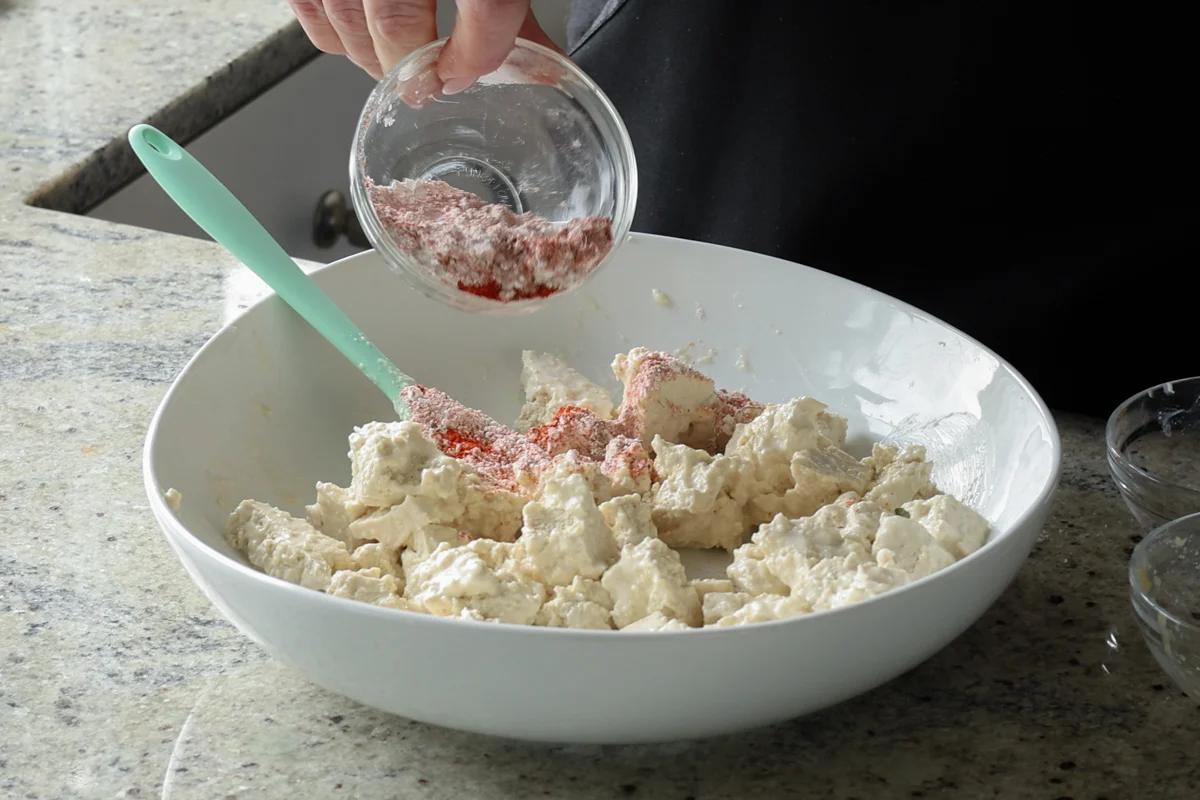 adding cornstarch and spices to the tofu