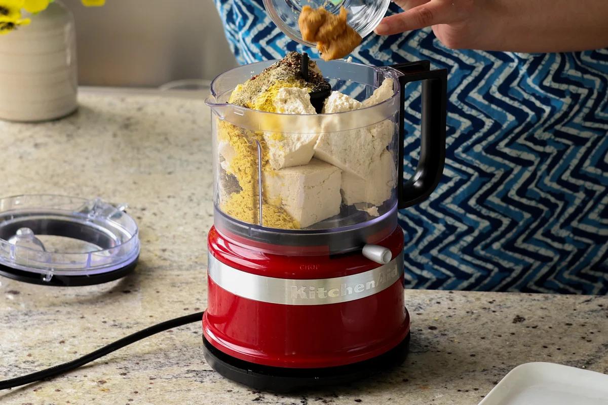 adding ricotta ingredients to the food processor