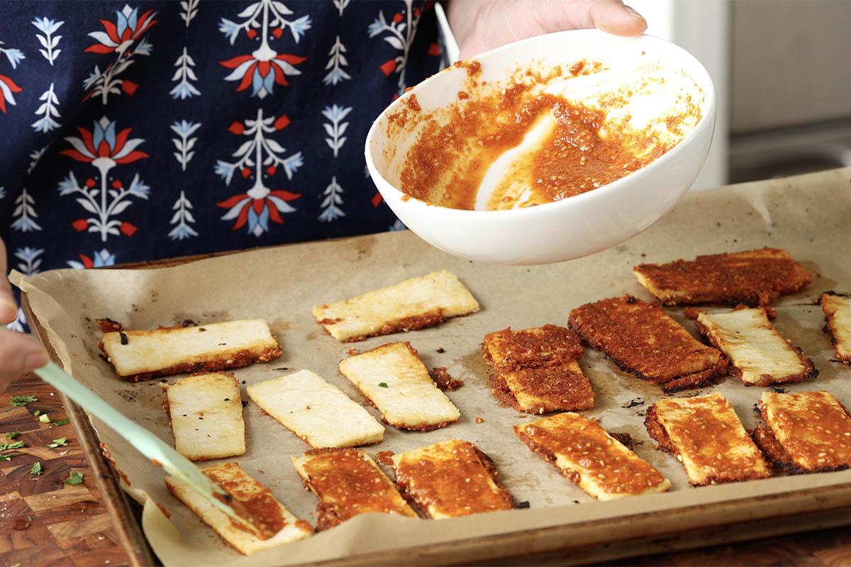 brushing the tofu with chili garlic coconut chutney after the first bake