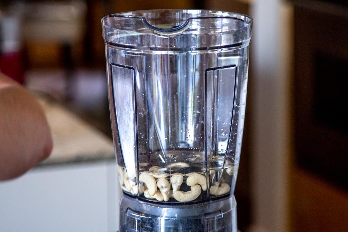 a blender with water and cashews