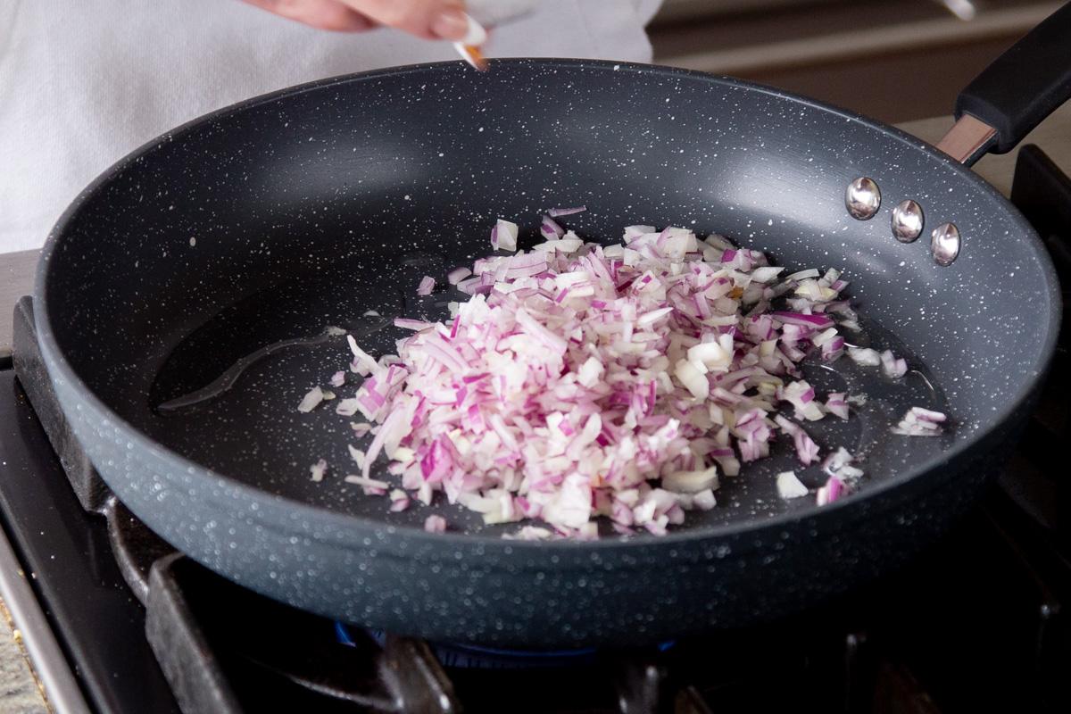 adding onion to the frying pan