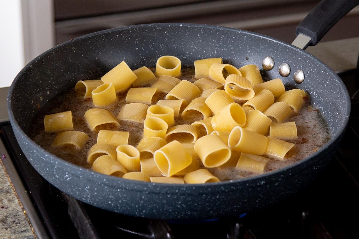 pasta added to the pan, before cooking