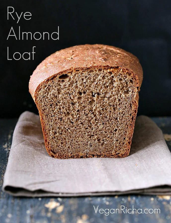 a sliced-open loaf of whole wheat rye and almond flour sandwich bread on a light brown kitchen towel