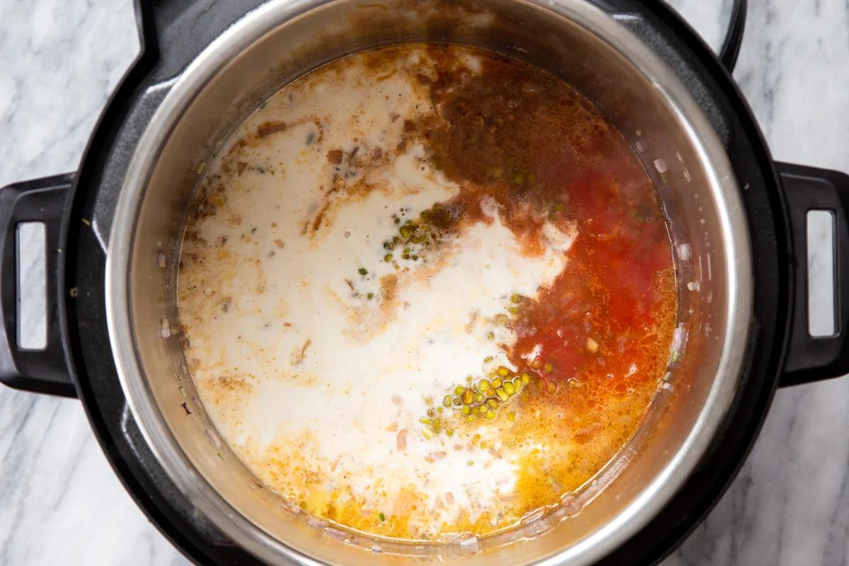 coconut milk being added to green mung beans, tomatoes and spices to make Instant pot dal