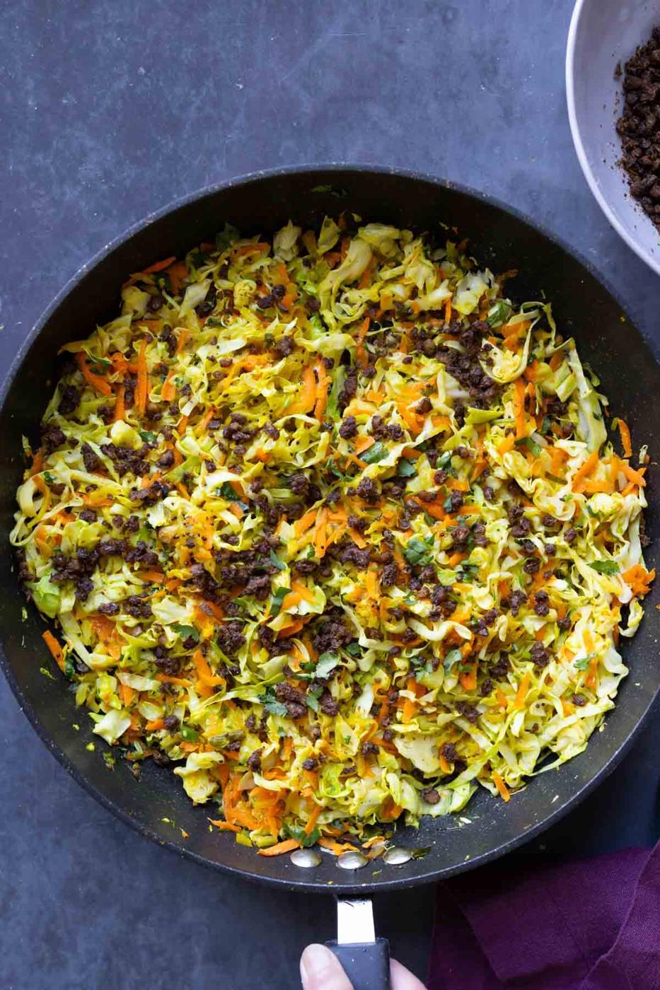 Indian cabbage salad in the pan after adding toppings