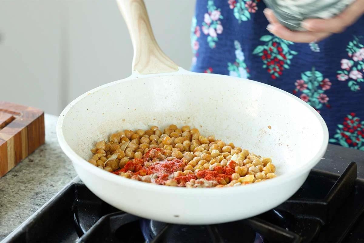 adding spices to the chickpeas