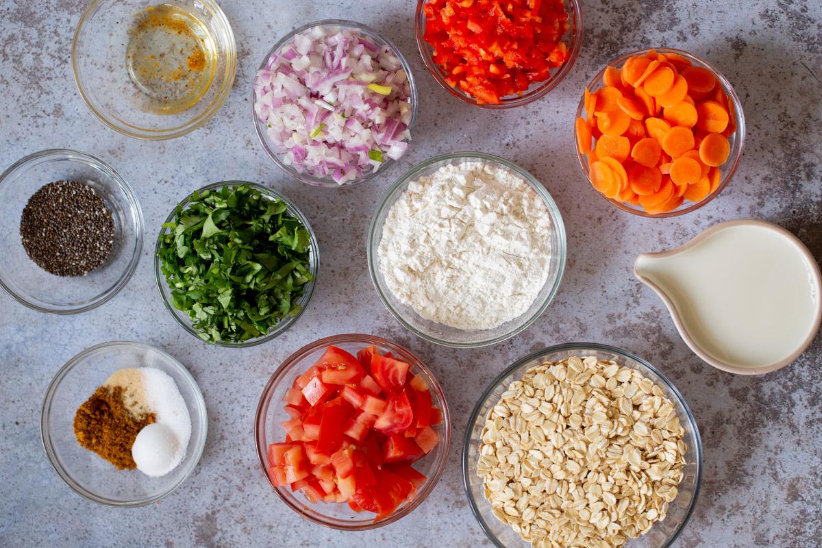 oats, flour, veggies, and spices in cups on a kitchen counter