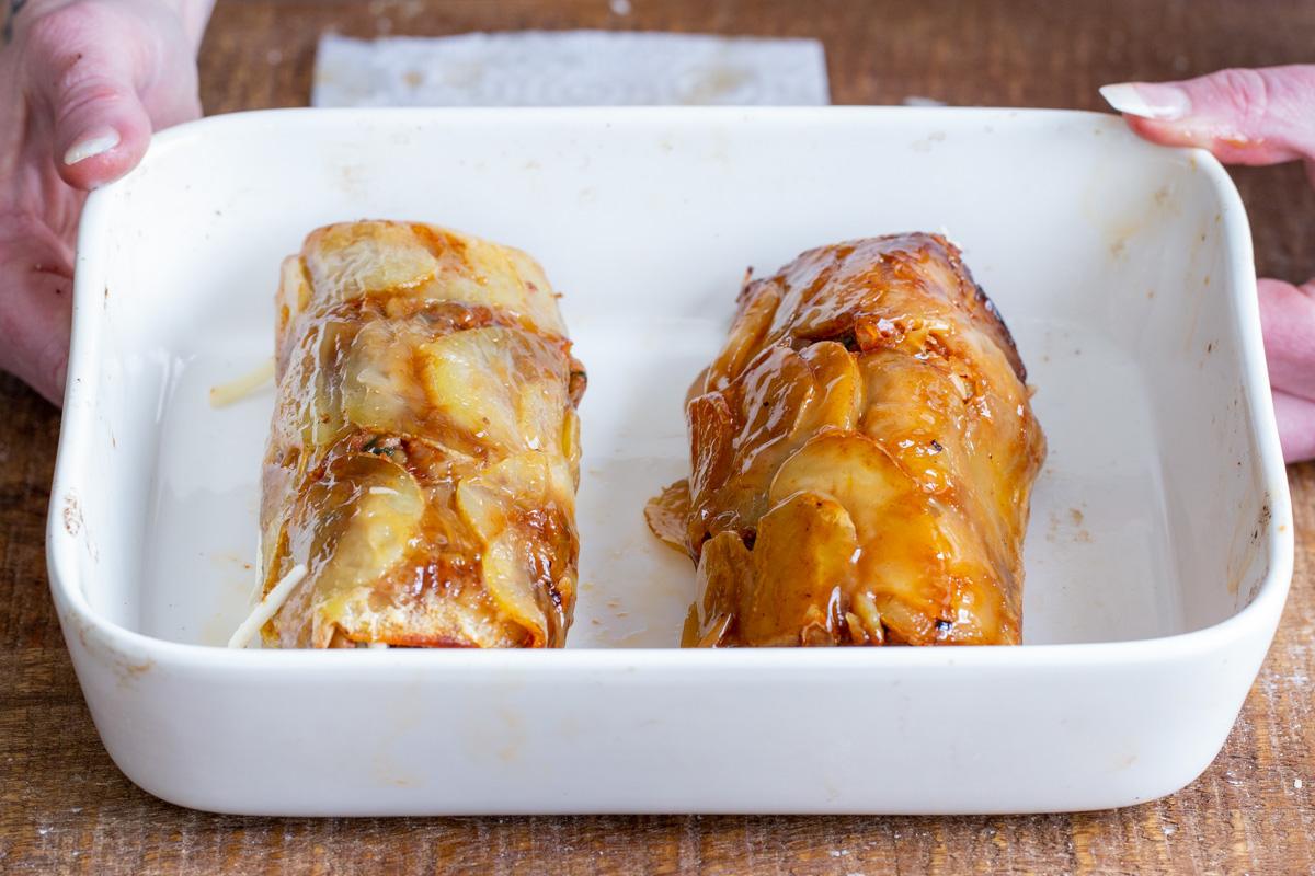 vegan scalloped potato rolls in a white casserole dish