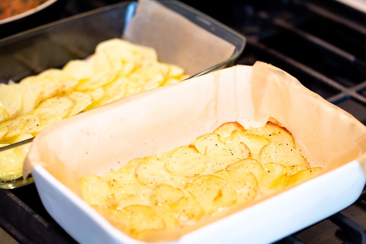 vegan scalloped potatoes baking in two casserole dishes