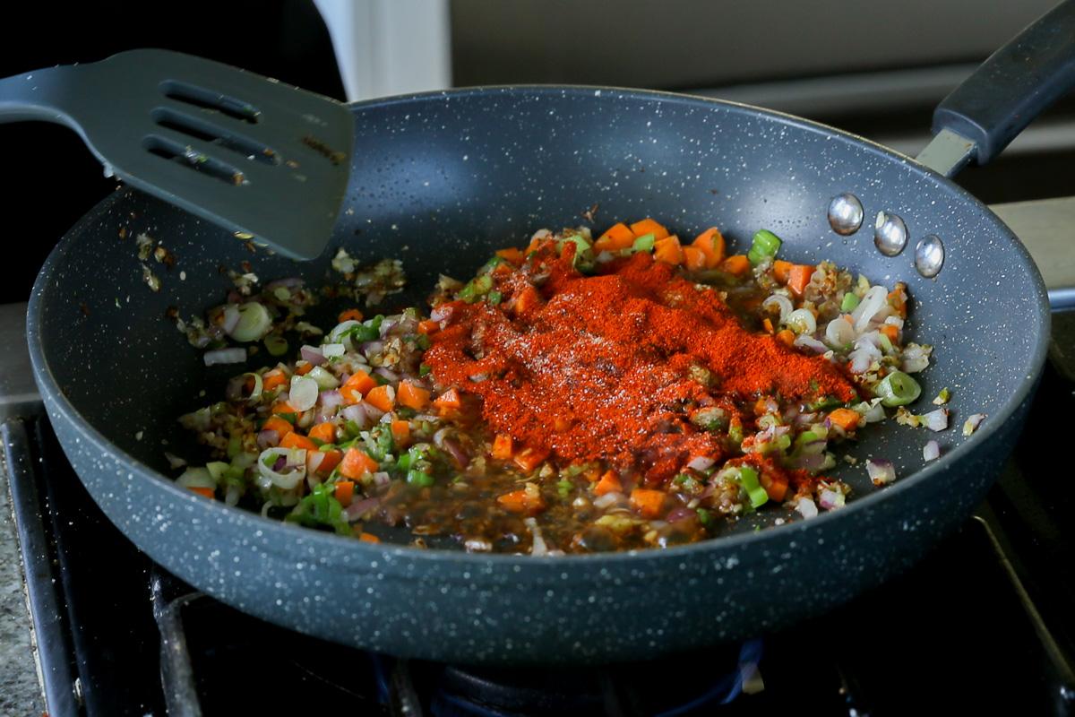 adding Kashmiri chili powder to the pan